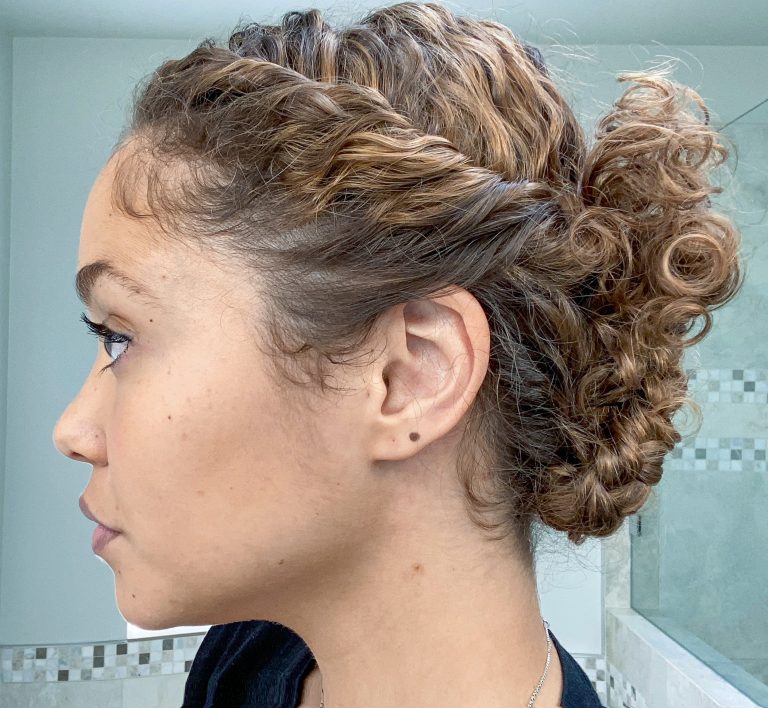 Updo with hair rolled down side into two braided buns at the base