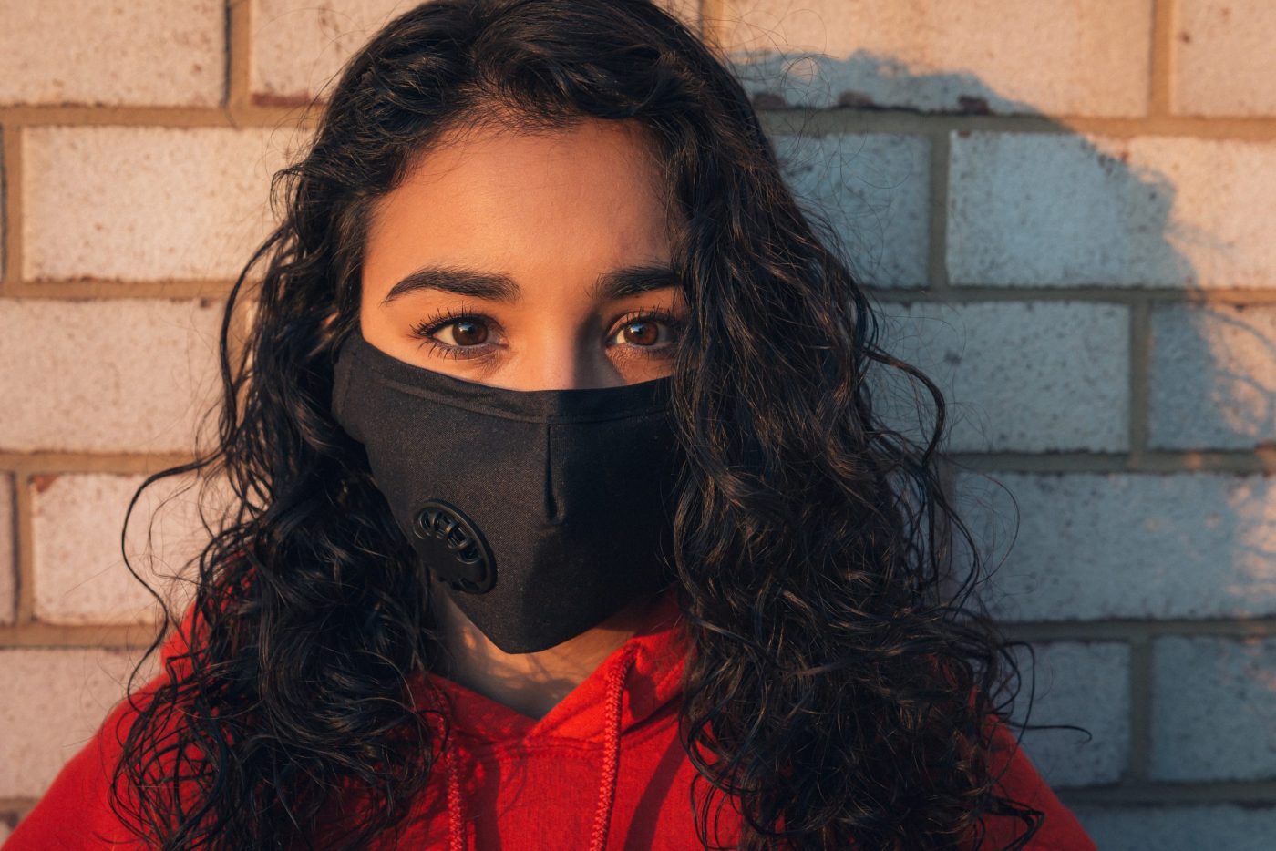 photo of a curly haired woman wearing a mask