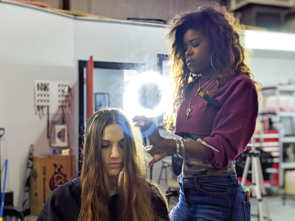 photo of woman with wavy hair getting her hair styled