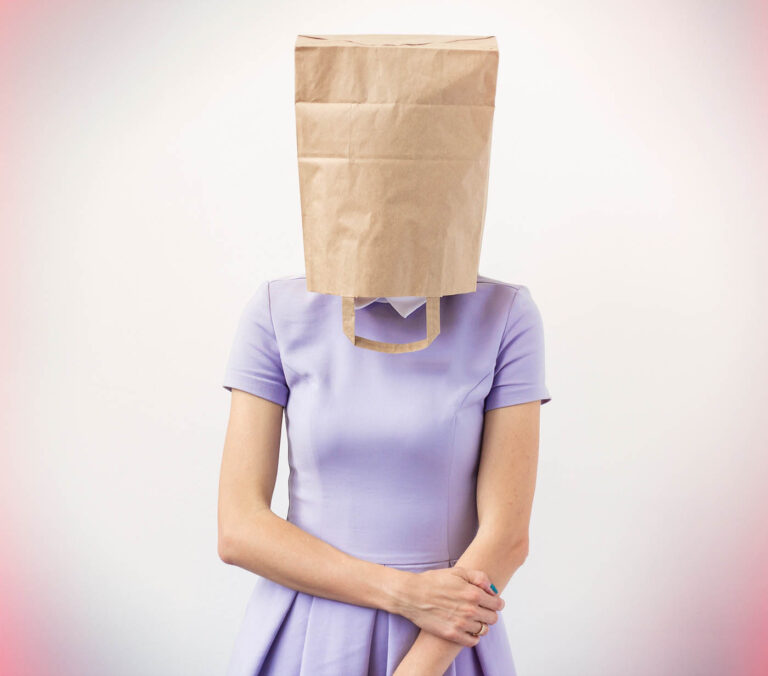 Woman in a purple dress with a paper bag over her head